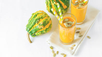 image of two gourds and pumpkin smoothies on tray with straws